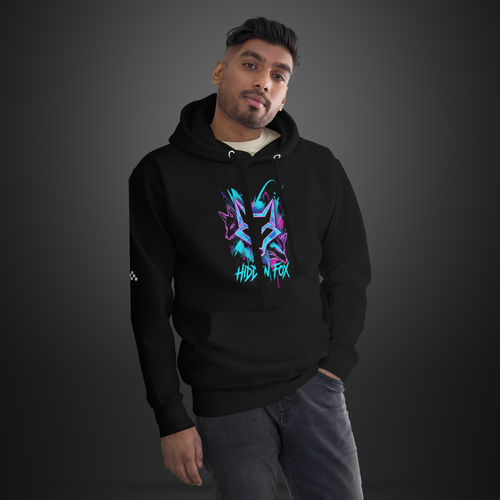 A man wearing a black pullover hoodie with a colorful graffiti-style graphic on the chest that reads 'Hidden Fox'. The background is a clean, dark gray studio backdrop.